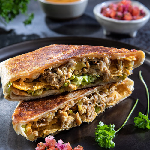 Ein knuspriges, würziges Pulled Chicken Crunchwrap mit Chimol und Guacamole-Füllung.