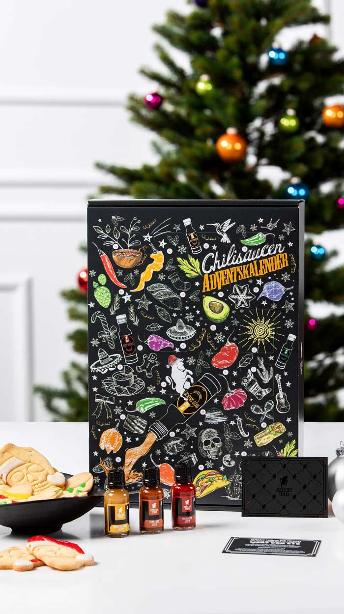 Weihnachtlich gedeckter Tisch im Winter mit vielen unterschiedlichen Weihnachtsgerichten gedeckt. Mit Tannenbaum und Lichterkette, während es draußen schneit.