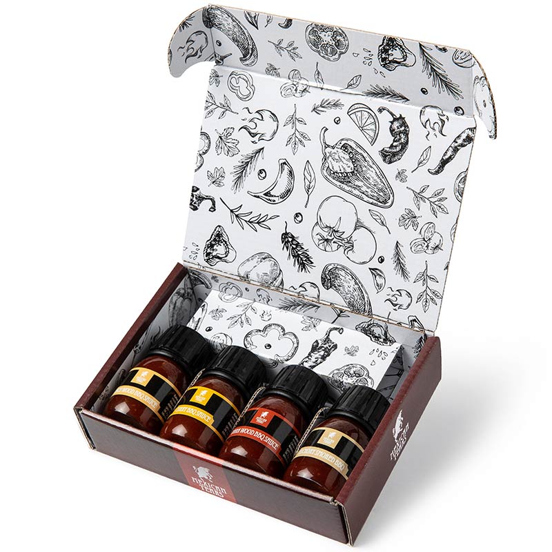 BBQ-Saucen Geschenkset – liebevoll verpackt, bereit zum Verschenken oder Vernaschen Geöffnetes BBQ-Saucen Geschenkset von Mexican Tears. Vier kleine Saucenfläschchen liegen in einer dekorativ bedruckten Box mit schwarz-weißen Grillillustrationen. Die Box ist hochwertig gestaltet und lädt zum Entdecken ein.