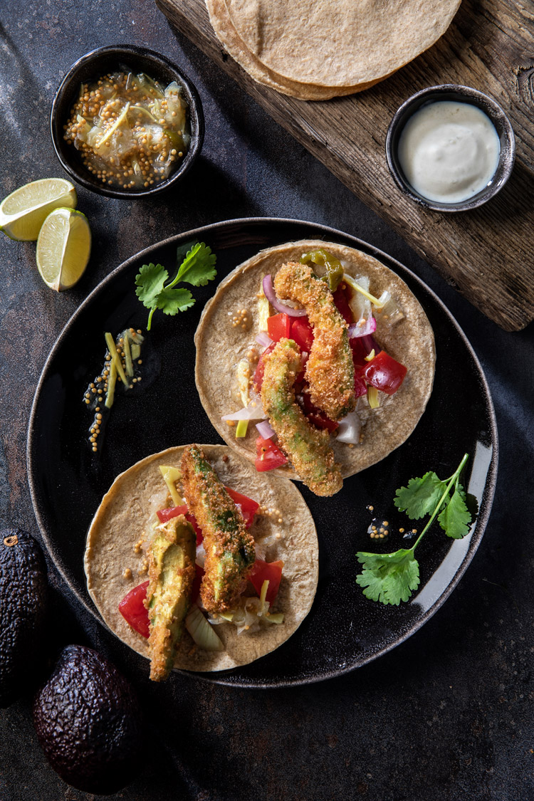 Knusprig frittierte Avocado-Scheiben mit würzigem Pico de Gallo auf einem weißen Teller serviert